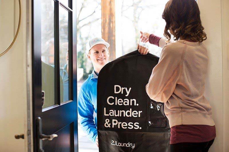 Woman handing off drying cleaning to 2ULaundry