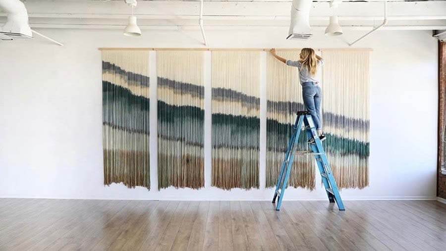 Lauren describes her work "as a bold statement piece, but with an organic and peaceful approach that has ultimately taught me so much about letting go." Each piece takes on a life of its own, and we can really witness that here. Image: James Williams Lauren installs a piece of fiber art