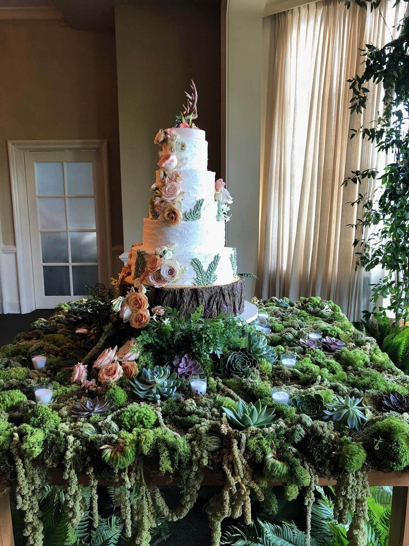 When opting for green foliage and florals, you can go for a more natural, earthy look, or you can keep things sophisticated and elegant. The options are endless. Image: Garden District Floral wedding cake surrounded by greenery