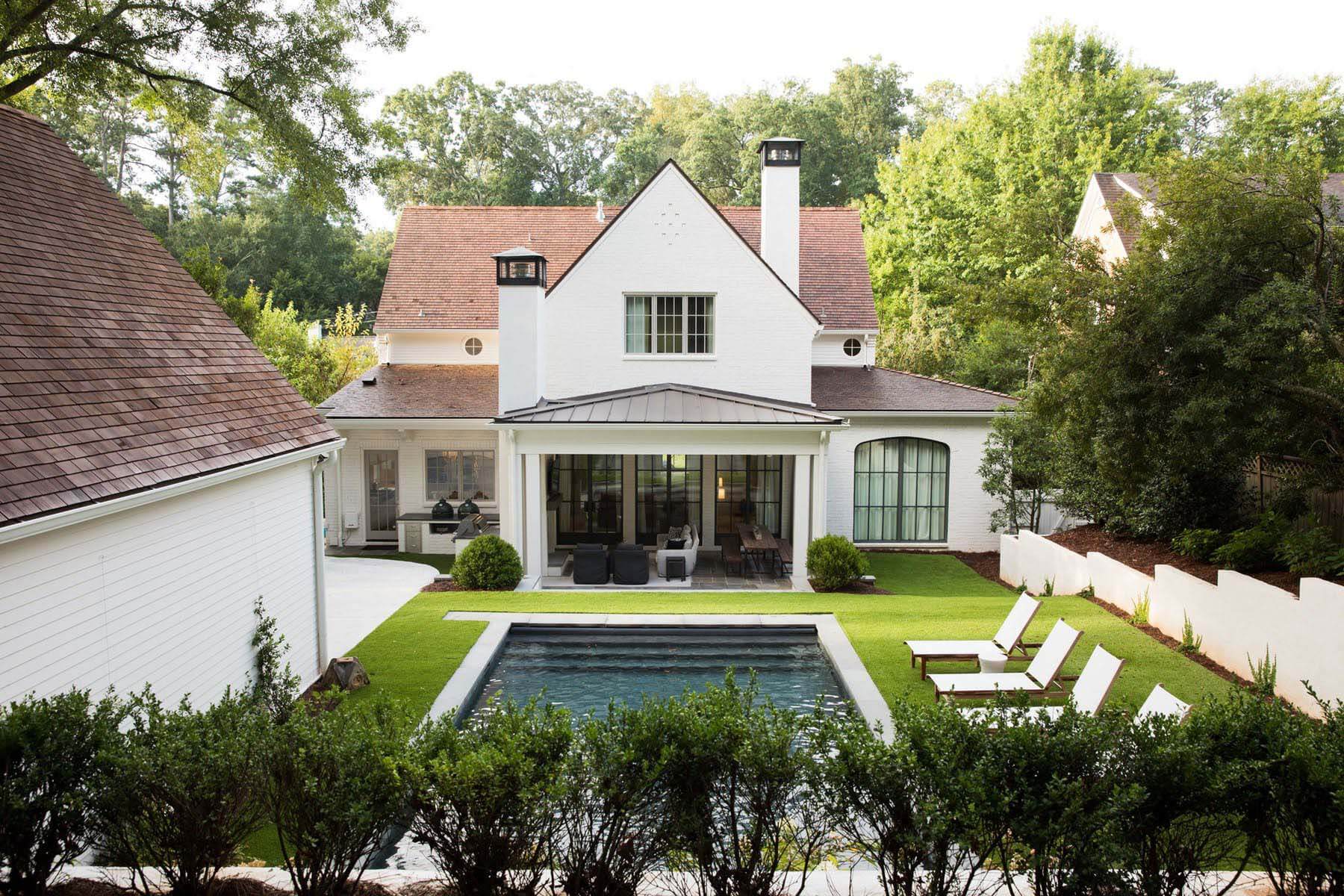 A covered rear porch provides easy access to both the outdoor kitchen and pool from the family room and kitchen. Hamilton Land Services http://www.hamiltonlandservices.com helped reconfigure the entire backyard. Aerial view of Orr home featuring backyard and pool