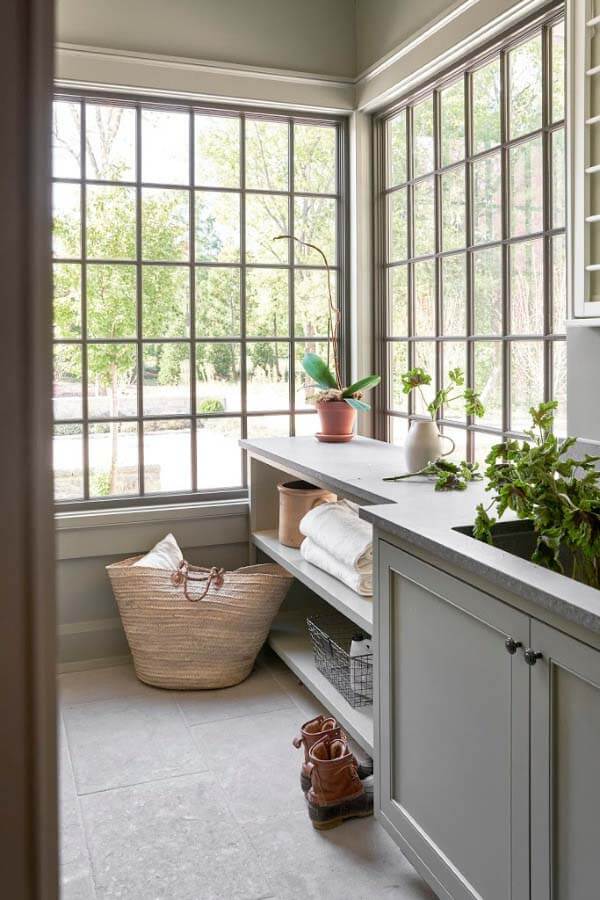 This gorgeous corner window, imagined and executed by Pfeffer Torode, makes for both a practical and beautiful laundry room. Showing it off by playing it up, the countertop runs straight into it with open shelving to allow for as much light to come through as possible. Of the design, Rachel says, "Unfortunately, We all spend a lot of time in the laundry room, so why not make it really cool?" Laundry room with big windows designed by Pfeffer Torode