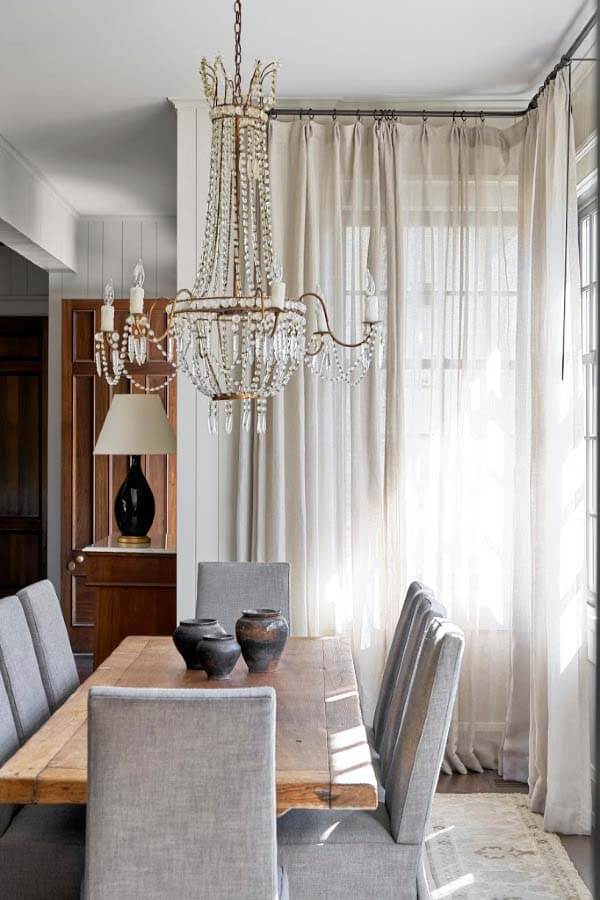 The dining room chandelier adds sophistication to the main living area, introducing an exquisite antique element to the family-friendly, casual space. Pfeffer Torode dining room design with antique chandelier