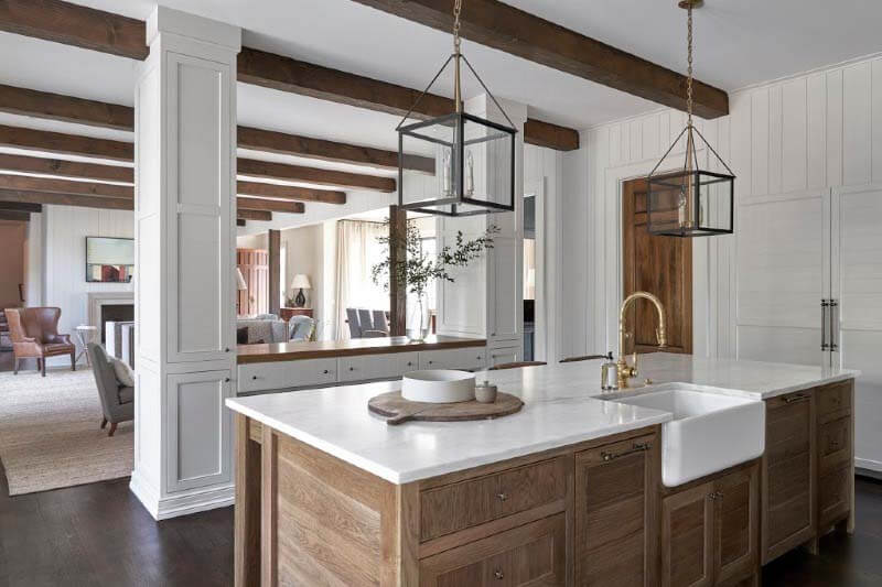 To avoid too many painted elements in close proximity, the designer opted for a stained island that feels more like a furniture piece. Stained kitchen island in Pfeffer Torode-designed home