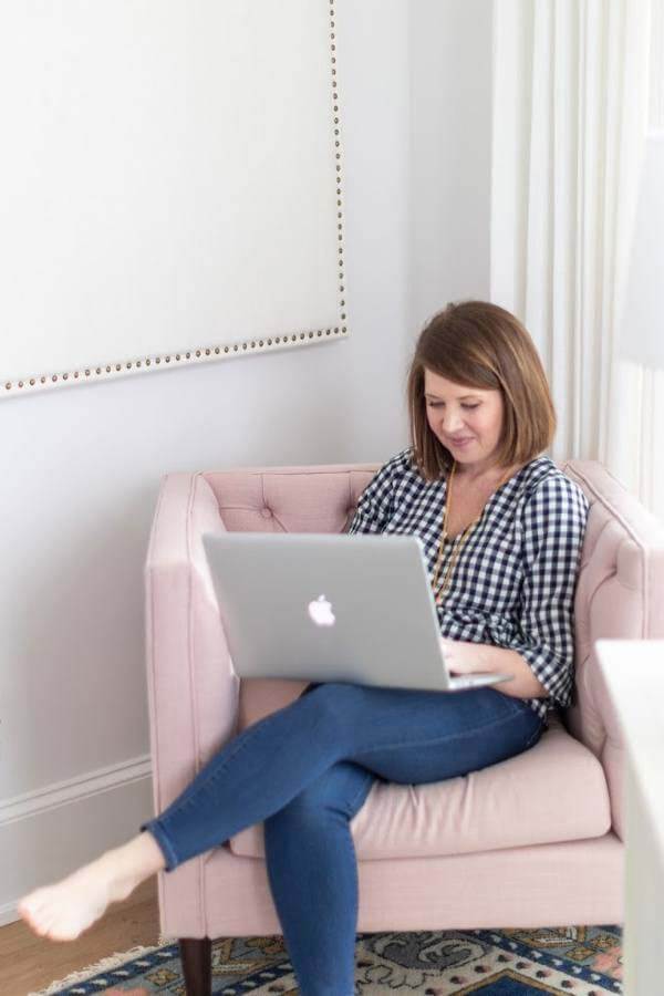 Emily Ley working on laptop in pink home office chair