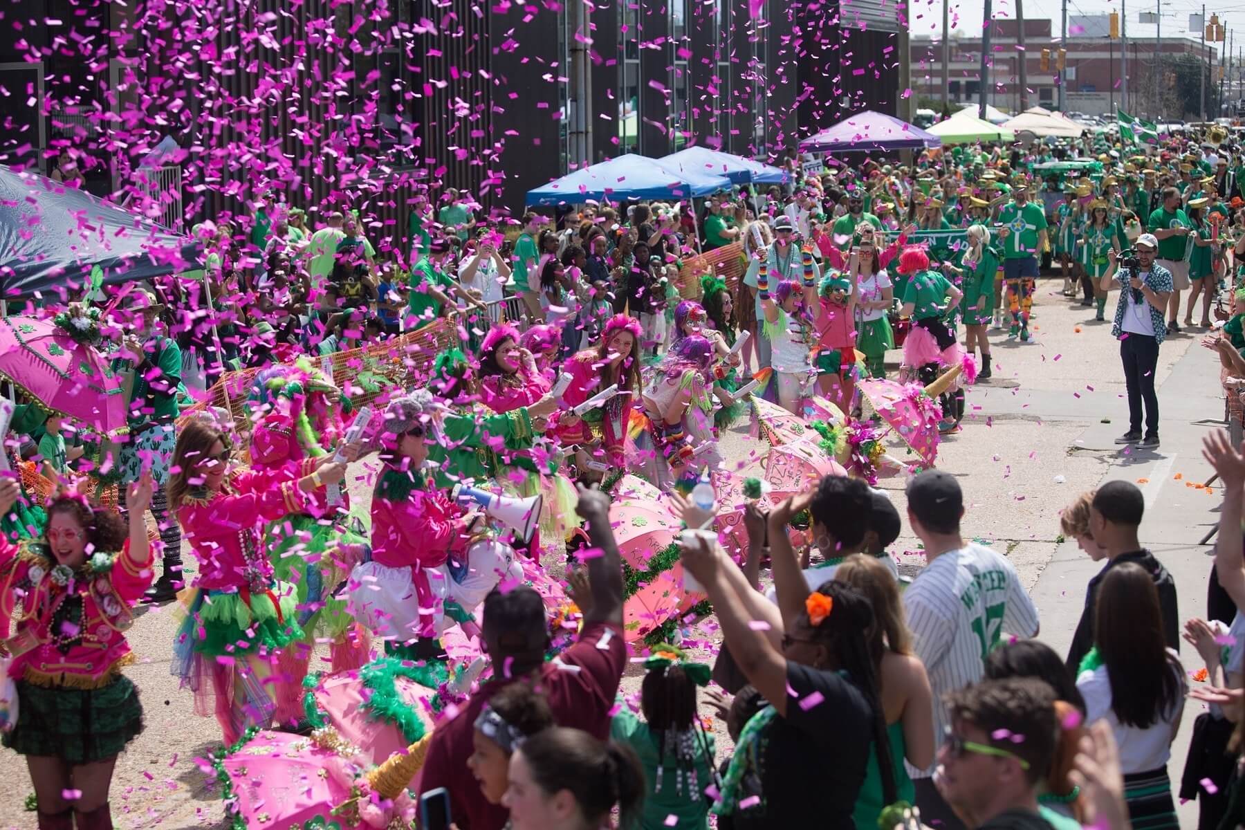 Crowd of people throwing confetti at St. Patrick's Day parade in Jackson, MS