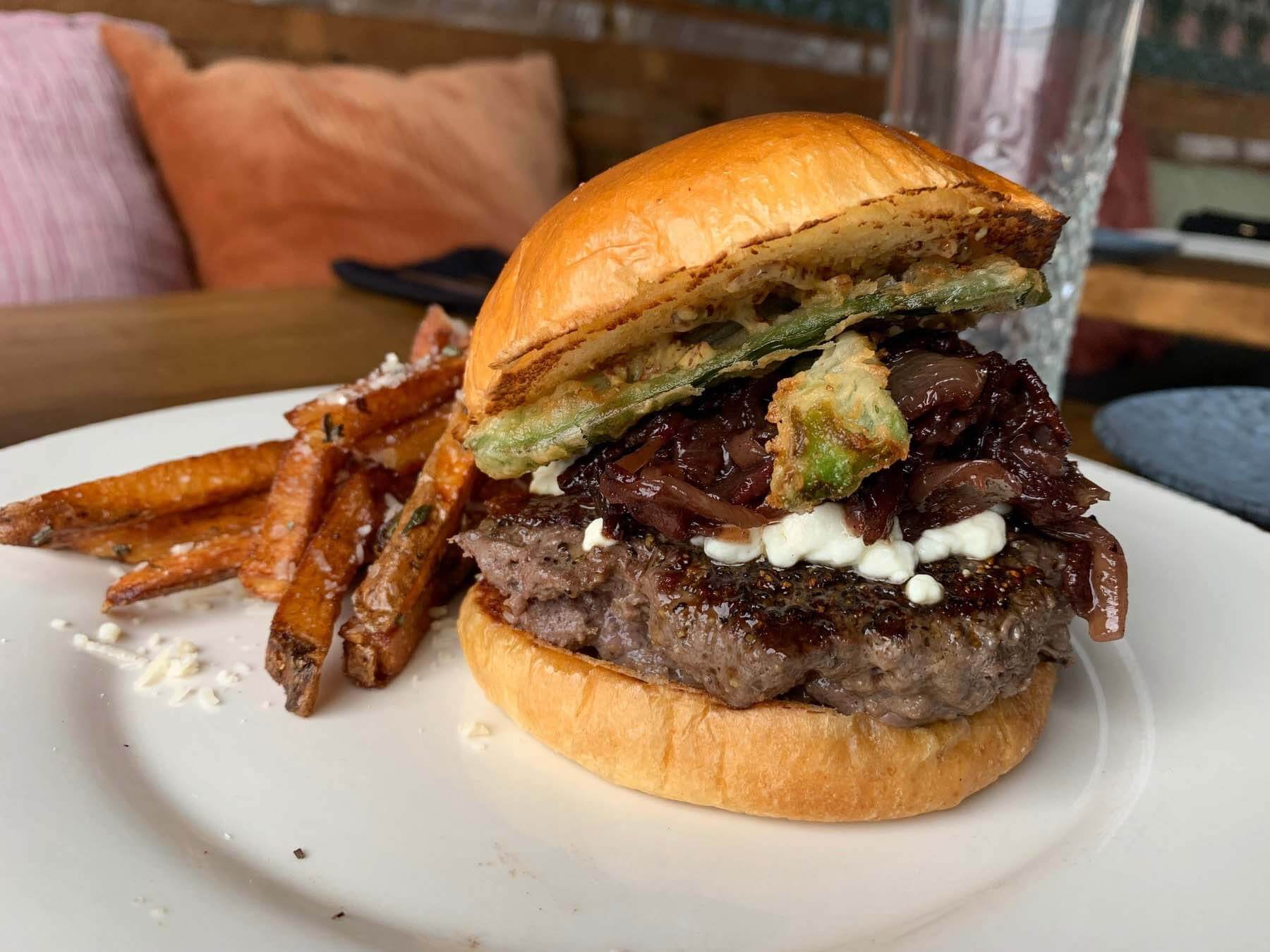 The Elk Burger features goat cheese, onion jam, fried jalapeño and housemade mustard on a brioche bun. Image: Lauren Helmer Elk burger from Watkins Branch
