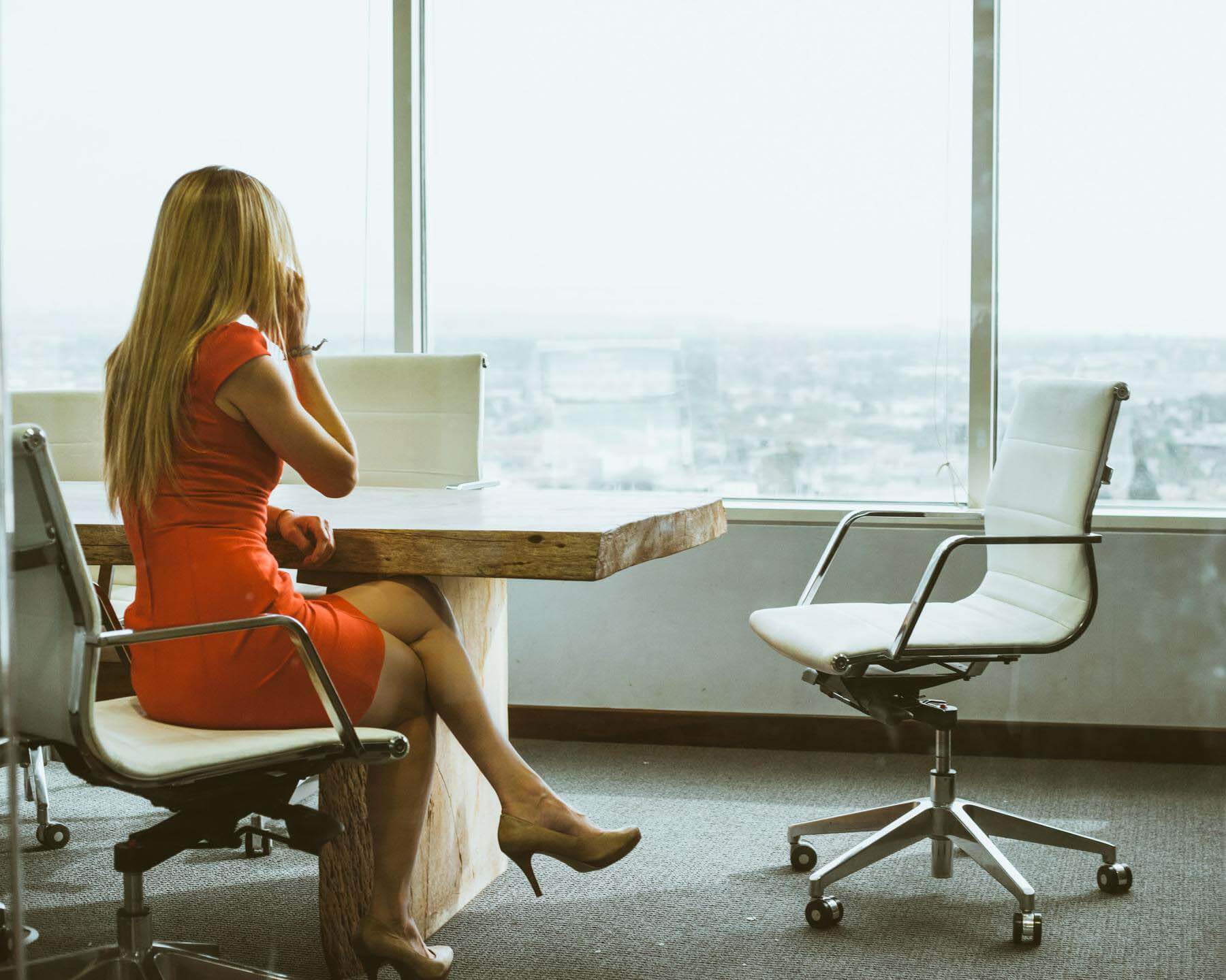 Woman at her office desk, crossing legs