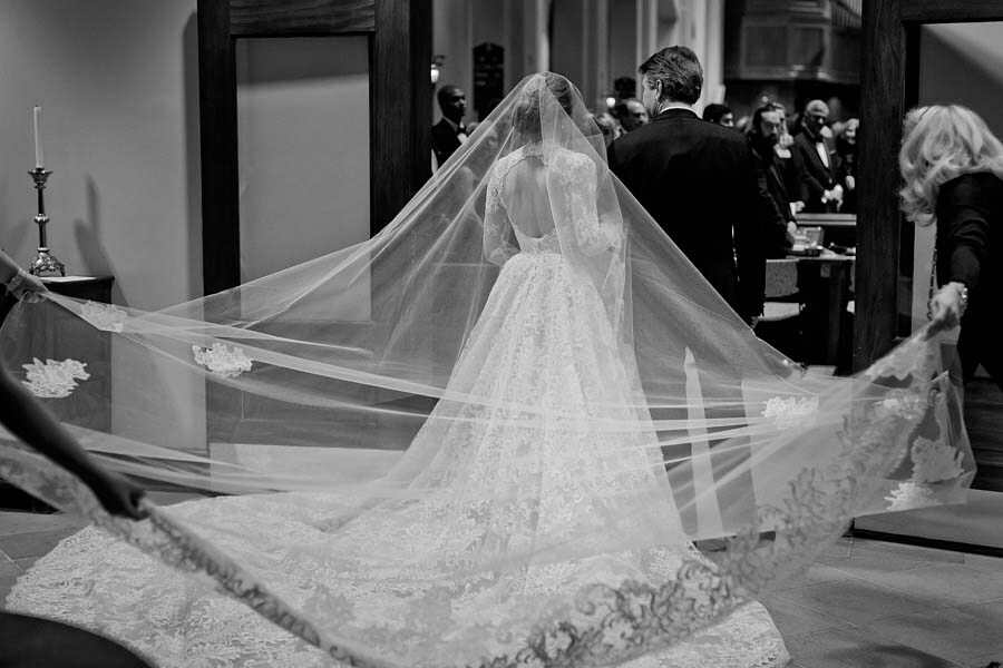 Getting the bride's train in order before walking down the aisle | Photographer: Kristyn Hogan