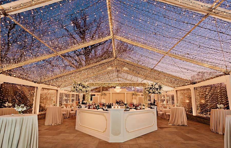Tent and lights at sunset during a winter wonderland wedding | Photographer: Kristyn Hogan