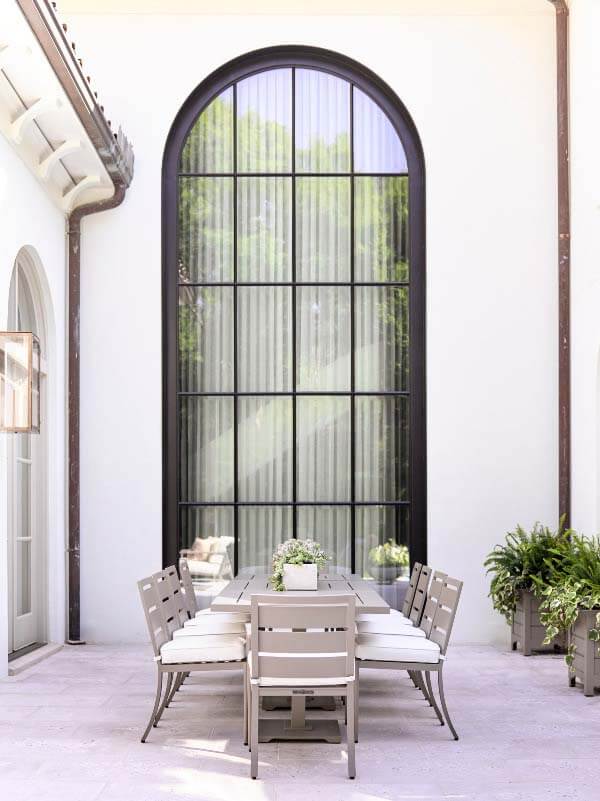 Giant domed window behind outdoor dining area at 2020 Southeastern Designer Showhouse