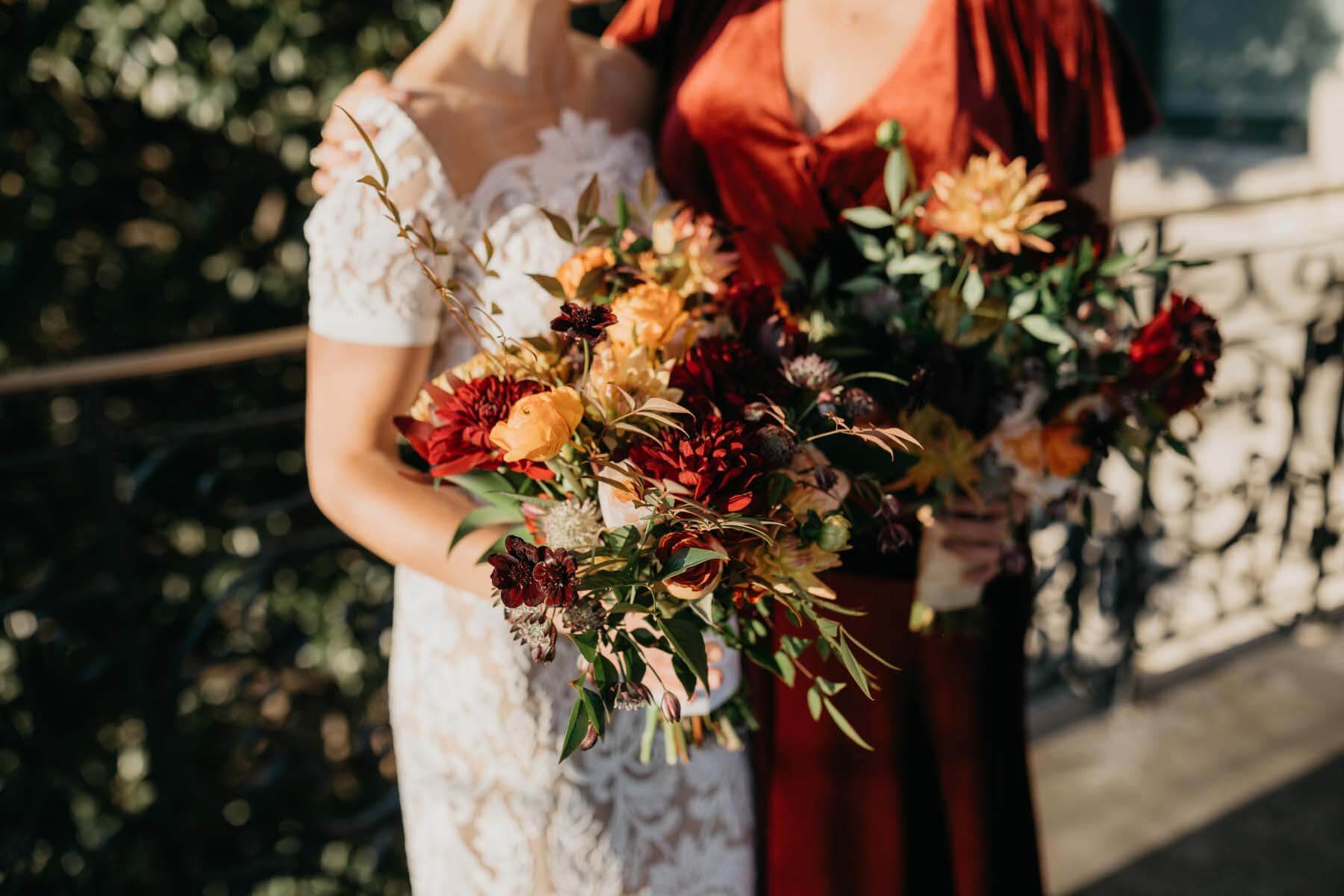 The bride and a bridesmaid with autumn floral arrangements