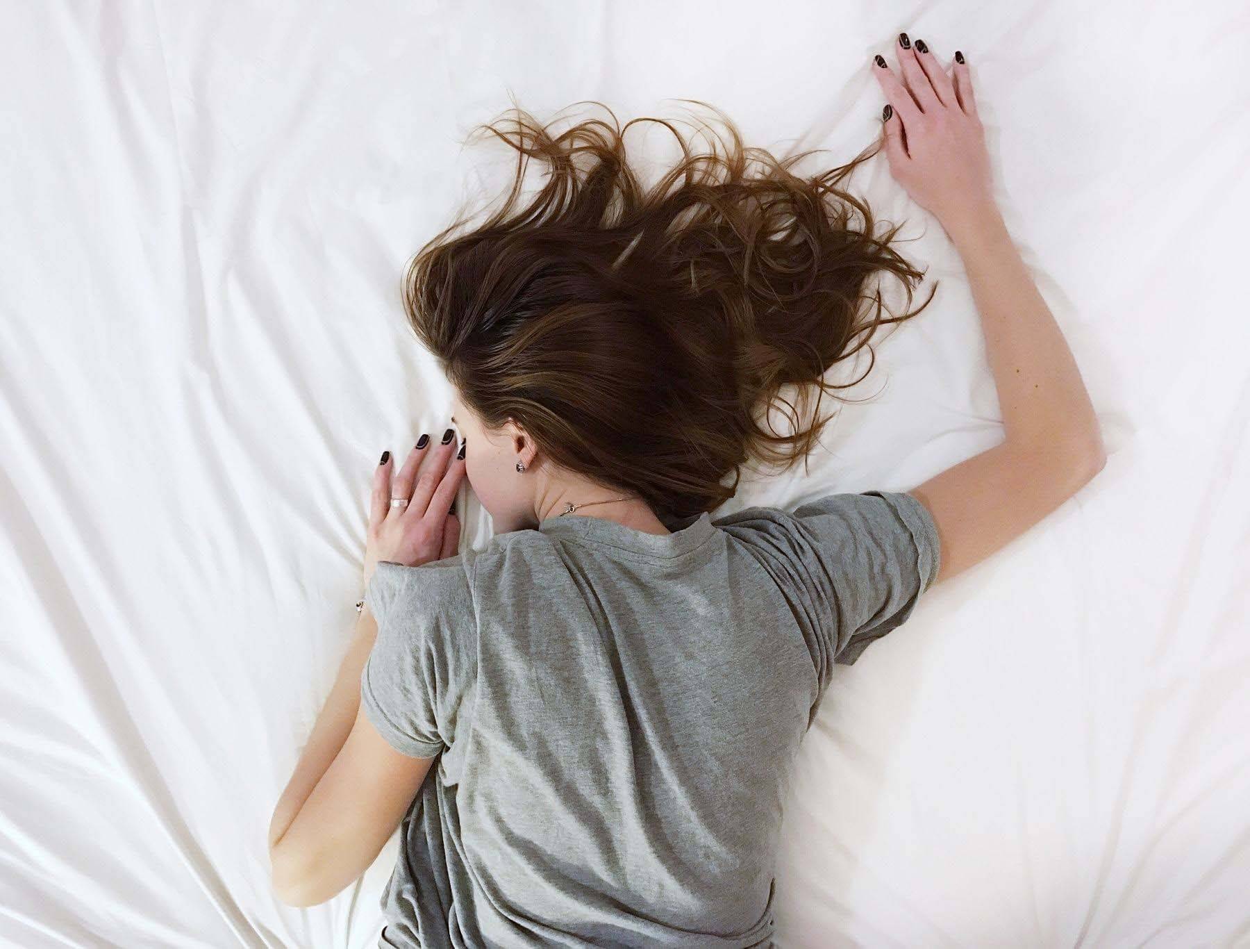 Getting enough rest has health benefits beyond our wildest dreams! Woman sleeping — beauty rest myth
