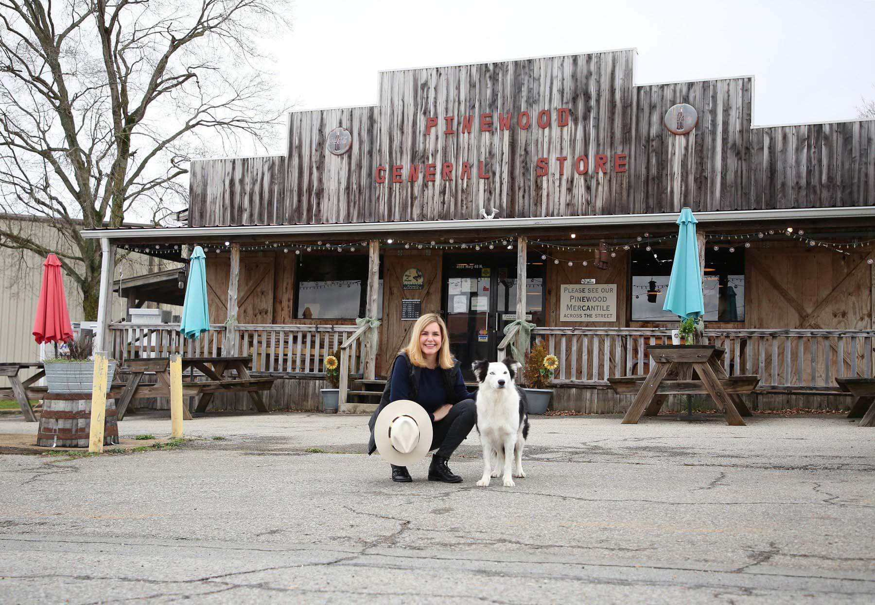 Mee's new Pinewood Kitchen soup line, called "Dat's Ma' Soup," is available online from the Pinewood site as well as at the restaurant and mercantile, along with homemade honey, jams and other delicious goods. She's pictured here with her dog, Jack. Mee and her dog in front of the Pinewood Kitchen restaurant