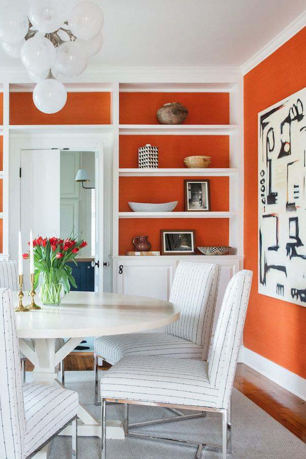 Dining room with orange grasscloth wallpaper