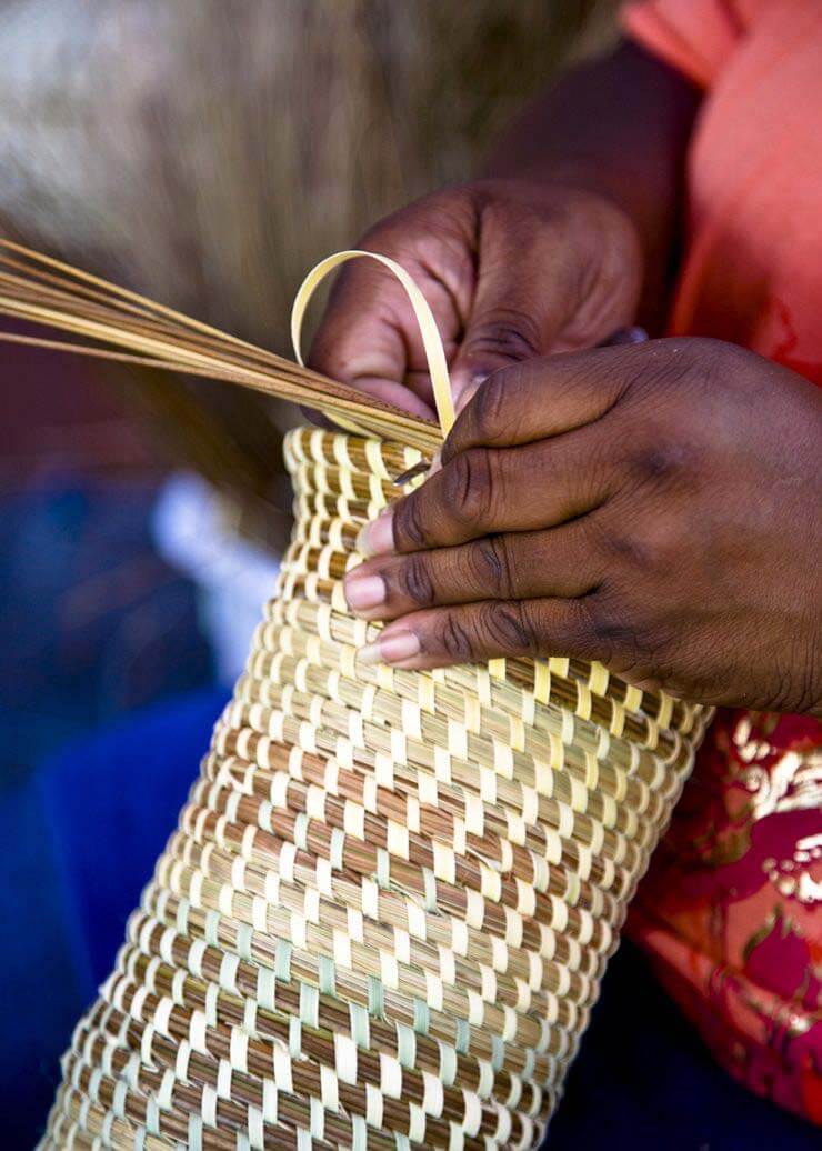 Long hours of work go into the creation of sweetgrass baskets, each one made by hand. Image: thecharlestoncitymarket.com Woman making sweetgrass baskets
