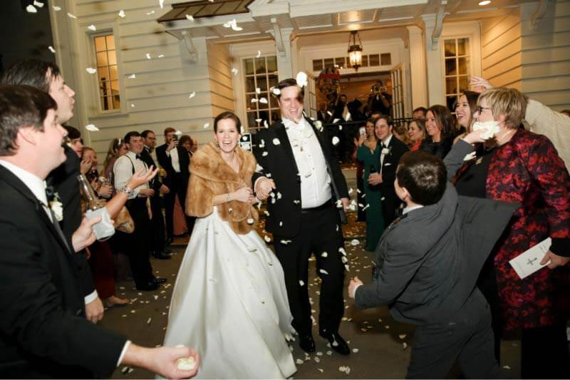 Bride and groom exiting reception to rose petals