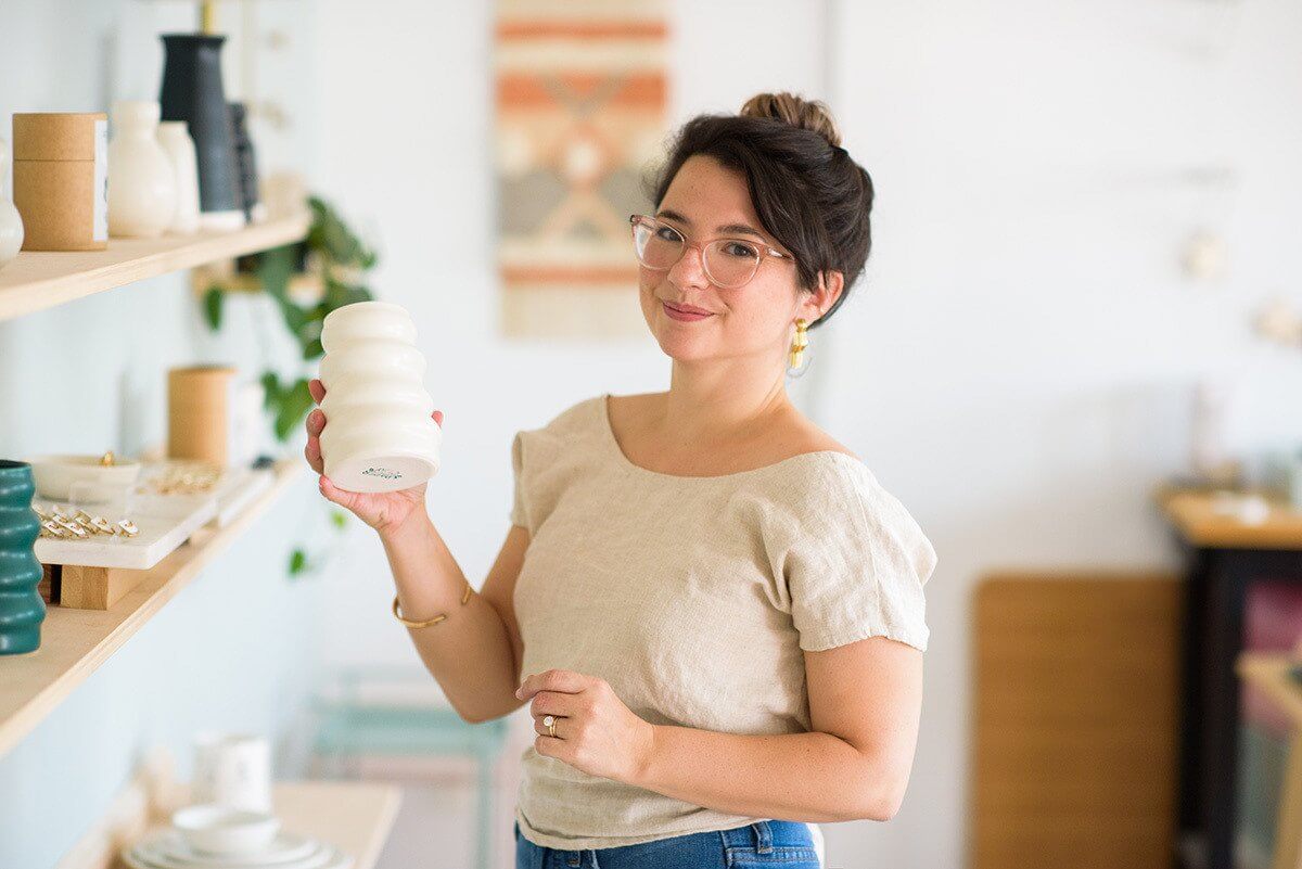 In addition to moving to a new store in South Main, Paper & Clay also announced a collaboration with Etsy and JoJo Fletcher to create a plate that is designed for cocktail parties. Image: Madison Yen Brit McDaniel posing with Paper & Clay vase