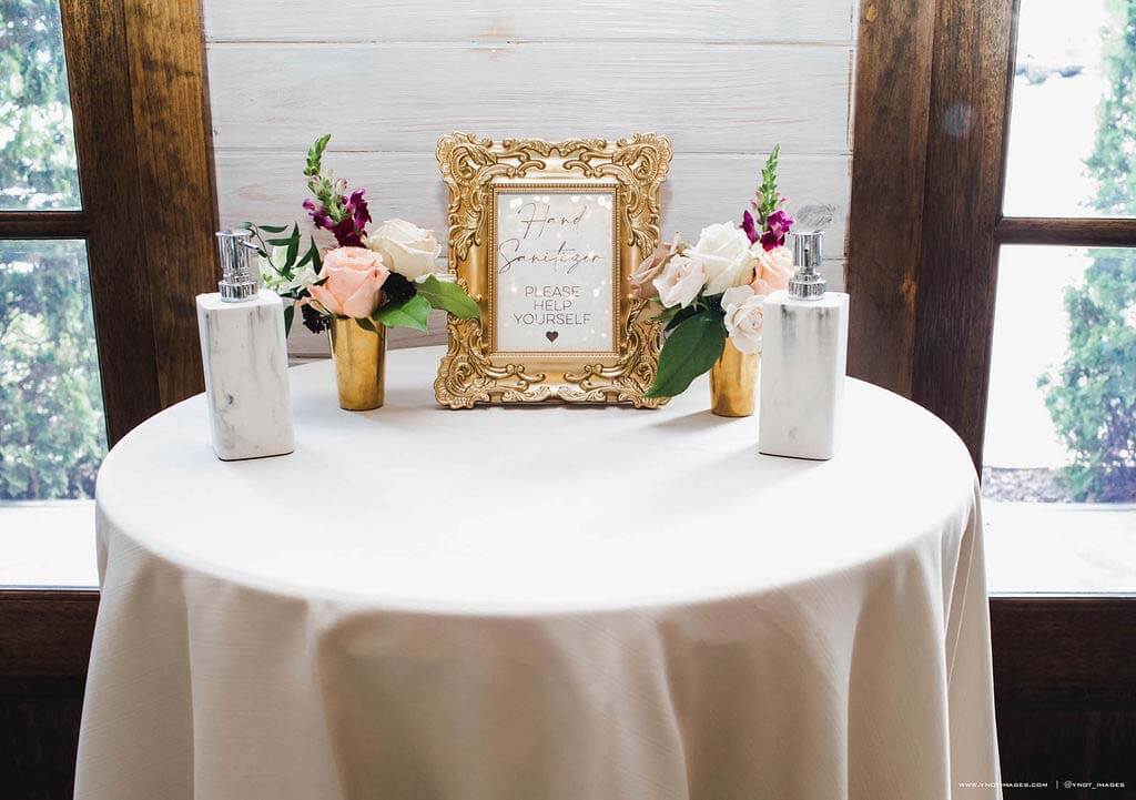 The Ervins took several safety precautions to ensure their family, friends and vendors stayed healthy. Wedding table with hand sanitizer