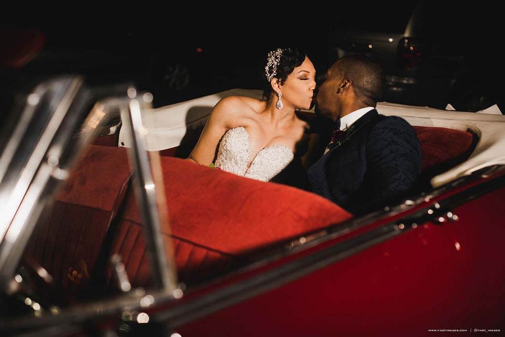 No Southern wedding is complete without a vintage getaway car, and this red droptop Packard from Rob Conrad's Classic Cars is absolute perfection. Couple leaving wedding reception in vintage getaway car