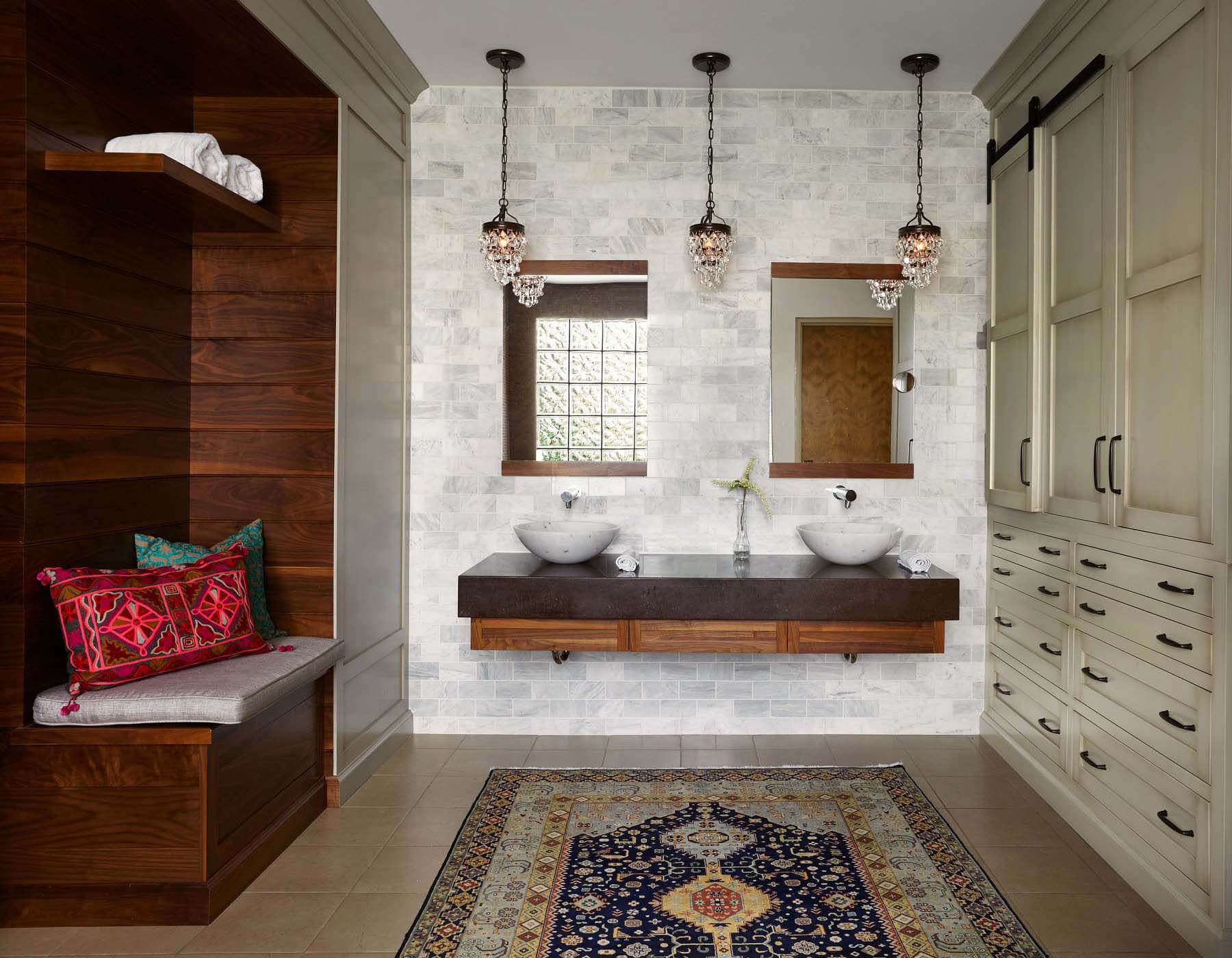 Updating the master bath, Marcelle added a built-in bench beside the vanities to create a sense of luxury, and to pull in the warmer finishes throughout the house. With exotic Mediterranean colors and patterns that reflect the client's heritage, the custom pillows and cushion turn the bench into a showpiece. Image: Gieves Anderson Built-in bench feature bathroom, an inspired room for interior designer, Marcelle Guilbeau