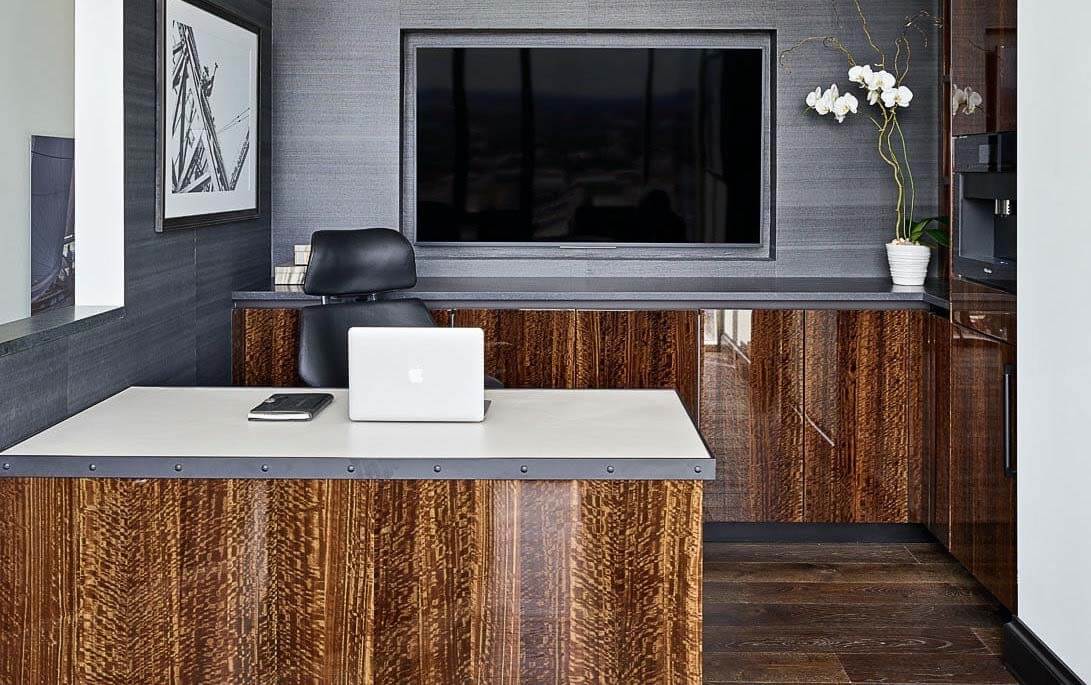 Though minimal, this elevated office space from Trace Ventures includes high-end features like a custom leather-topped desk, eucalyptus wood built-ins, textured walls, a recessed television and hidden storage. Image: Trace Ventures Home office, an inspired room by Trace Ventures