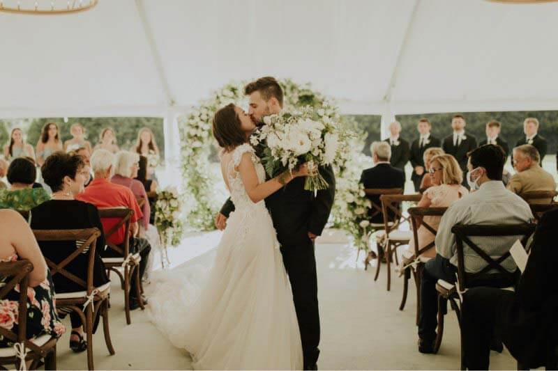 Introducing Mr. and Mrs. Hunter Grubbs! The bride and groom kiss at their French country-themed wedding