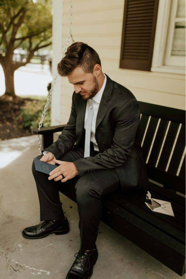 Hunter takes a moment to sit on the porch swing and read his special card from Jordan. The groom sits on a porch swing and reads a card from his bride