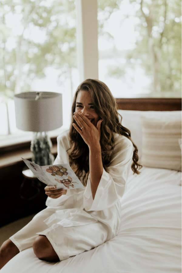 The bride and groom exchanged pre-wedding gifts — a watch for Hunter and earrings for Jordan. Here, the bride laughs with delight over the card from her almost-husband. Bride opening card from husband on wedding day