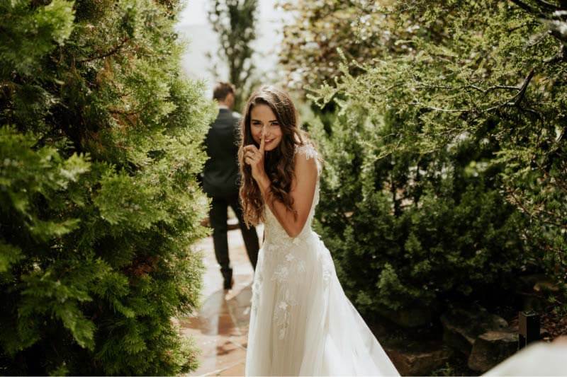 The intermittent rain couldn't deter the bride and groom from first looks in the Serenity Garden. "We actually got all of the doormats from inside and laid them out so my train wouldn't get muddy," says the bride. A bride and groom's first looks in the serenity garden