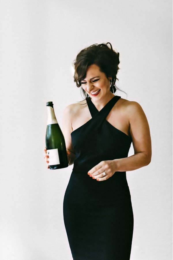 Nikki says her store is a reflection of her personality. She wants brides to shop without fear or judgment, creating a space where they can be themselves. Nikki holding champagne
