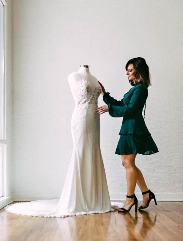 Nikki gives an unforgettable shopping experience by being what she calls a "hype woman" for brides. "I want them to have the most memorable experience and never forget how they felt when they found 'the one,'" she says. Nikki adjusting mannequin