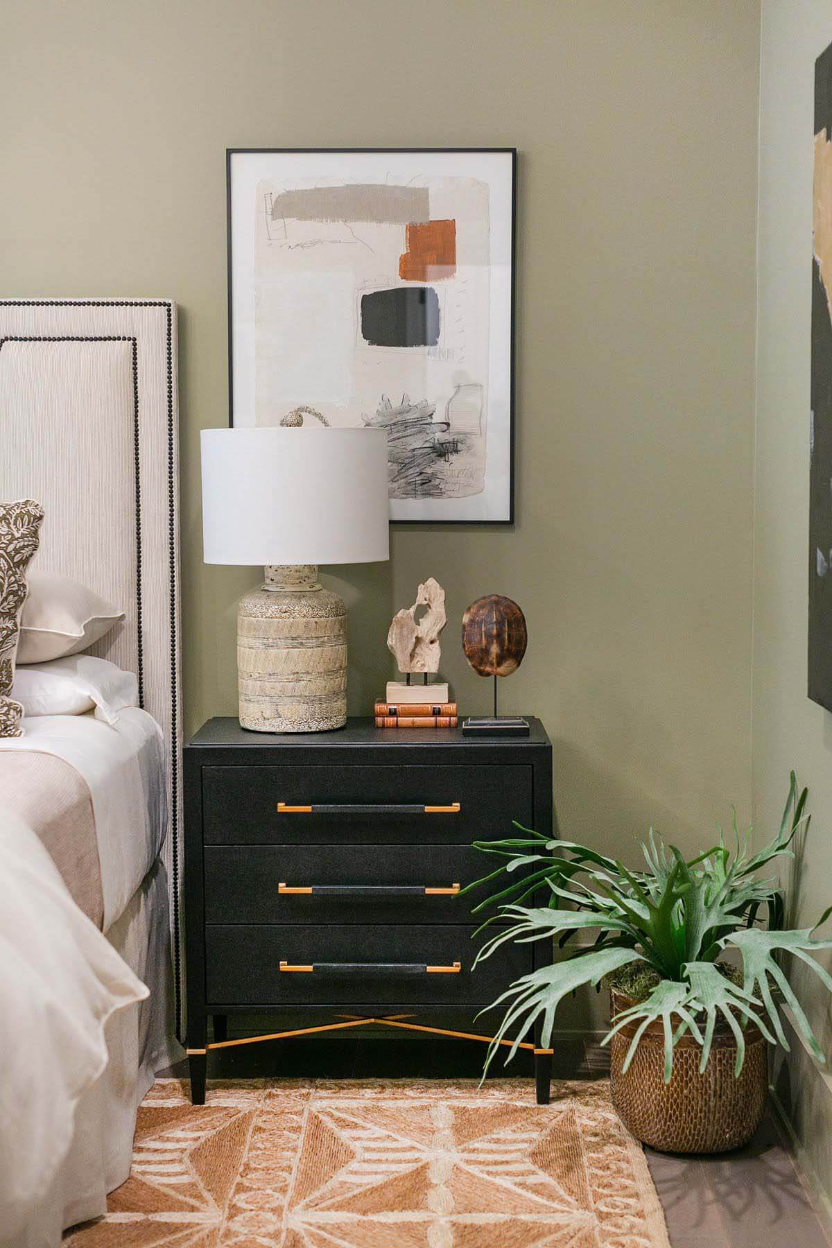 Designed by Ashley Malone of Bennett Malone Interior Design, this bedroom's olive green walls, unique wall art and greenery create a relaxing and luxurious escape Bedroom by Ashley Malone of Bennett Malone Interior Design at 2020 Serenbe Designer Showhouse