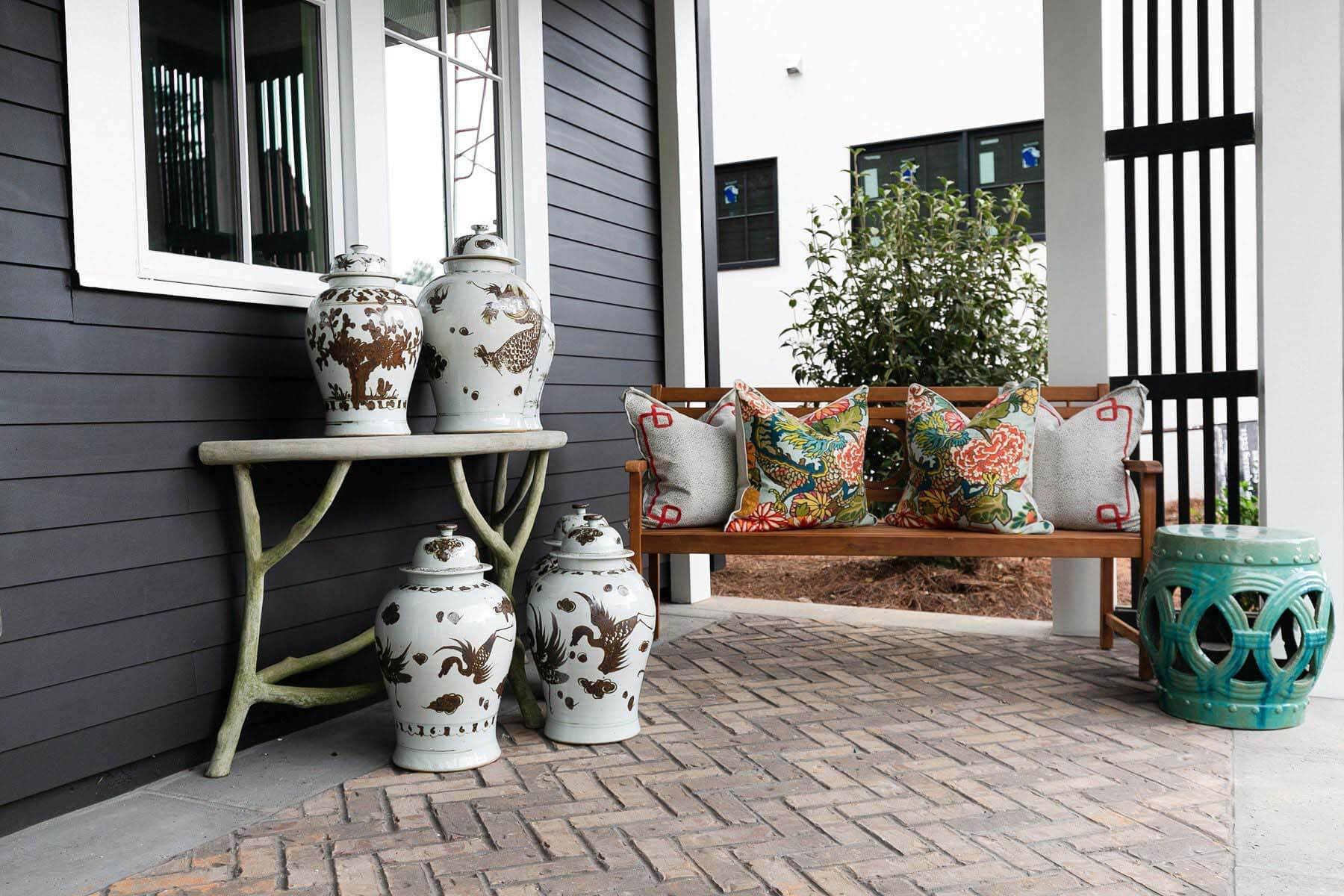 Bright colors, bold patterns and vintage decor adorn the front porch, serving as the perfect contrast to the earth and mineral tones seen throughout the interior. Porch designed by Whitney Durham at the 2020 Serenbe Designer Showhouse