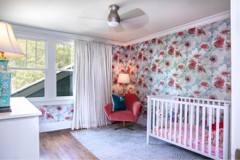 Girl's bedroom with crib and floral wallpaper