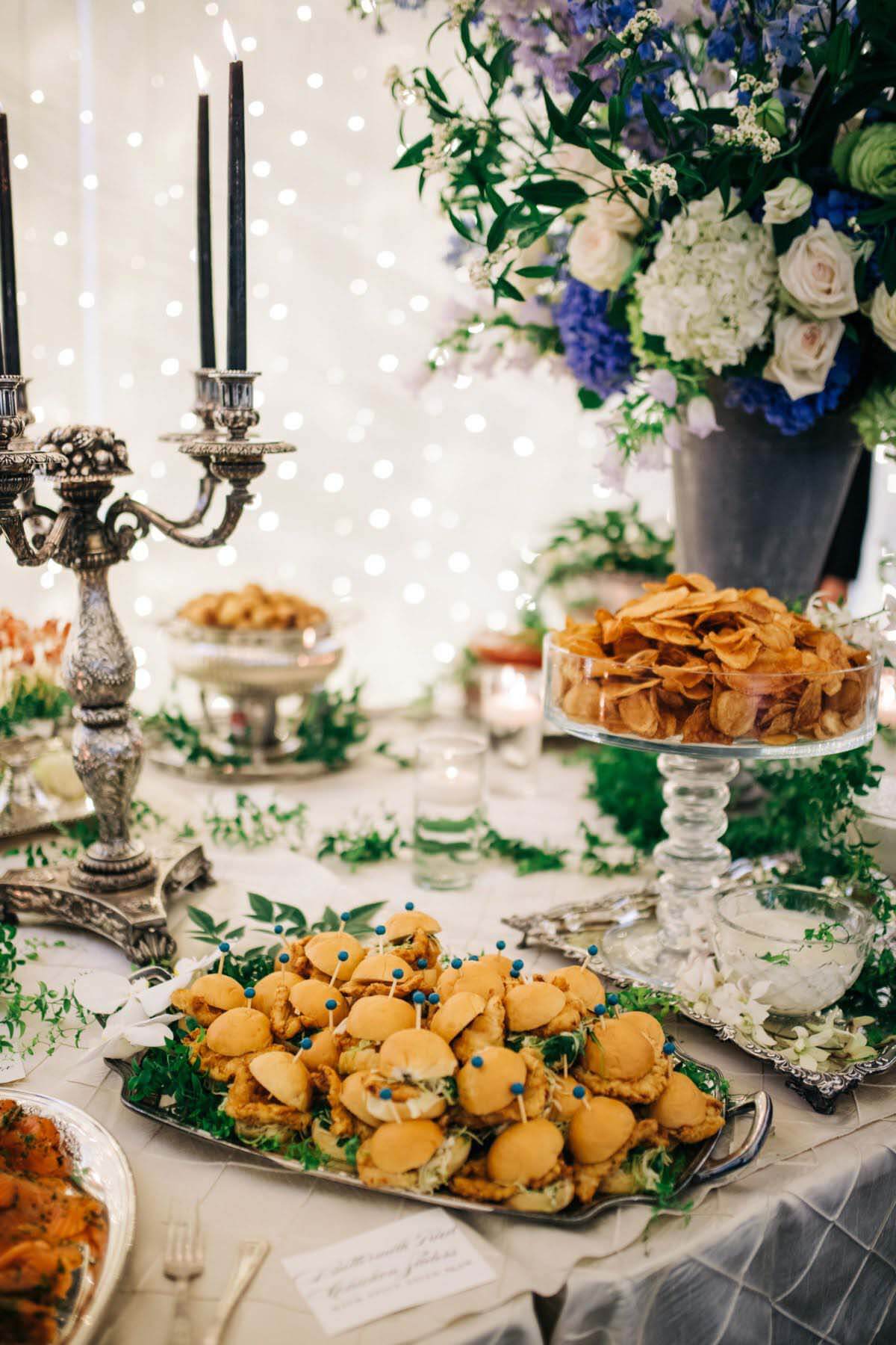 Due to pandemic stipulations, no servers were able to assist with the wedding meal service. Mark and Allison opted for a buffet-style feast from River Oaks Restaurant — one that guests raved about! Buffet table draped in fresh flowers and greenery in Chickasaw Gardens