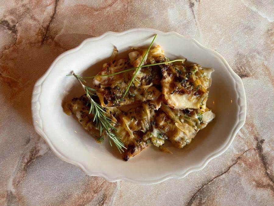 Kick off your meal with these can't-eat-just-one savory tarts! See below for the full recipe. Image: BRND House New Year's Eve menu appetizer: French Onion Tart with Gorgonzola, Tarragon & Brie