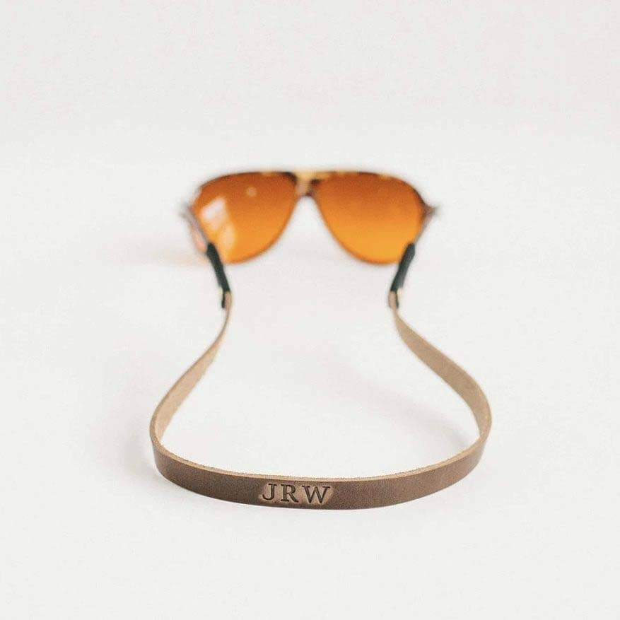 Order Clayton & Crume products by December 15 for on-time Christmas delivery. Leather monogrammed sunglass straps on sunglasses by Clayton & Crume