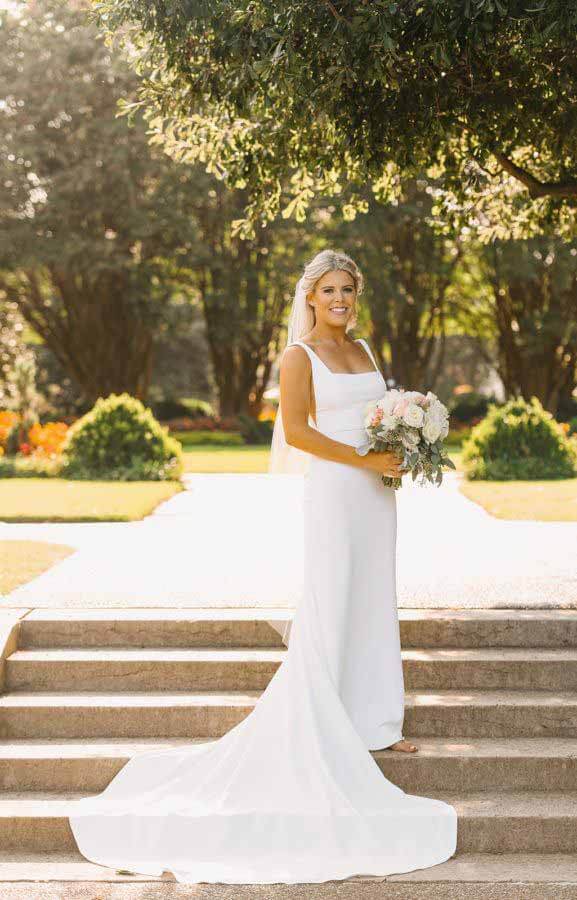 Haley Young in wedding dress, holding bouquet of flowers