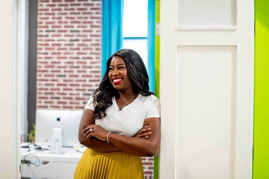 If you were to hire Nicole's team, they start by reviewing your financial and legal foundations, making sure that when you make your first dollar, you're prepared to keep it. Next, they make sure to build a product that is solid, ready for the consumer, and ready for market. "Of course, it sounds simple, but we do all of this in a dynamic and evolving way, so it feels natural, fun, and in alignment with exactly where our clients want to be. I like to think of myself as the best friend with the awesome advice that gets you paid!" Nicole says. Nicole Walters posing in doorway