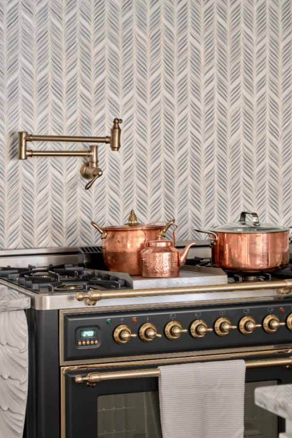 freestanding oven with tile backdrop, pot filler and copper pots