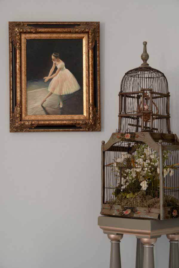 Birdcage with painting in the corner of the parlor at a renovated Victorian home