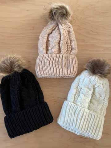 Knit beanies, $32 each, at Abednego | Image: Abednego Knit hats with pom-poms from Abednego