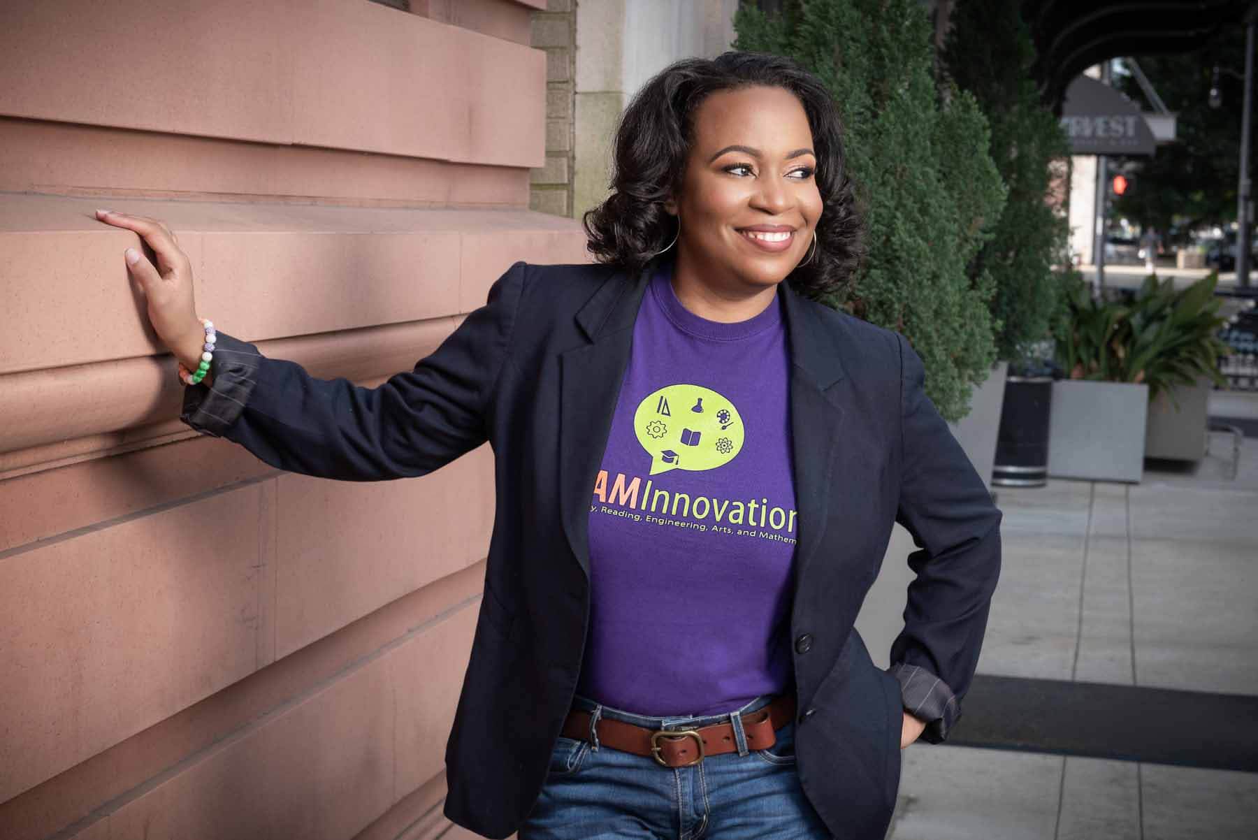 Dr. Starks launched STREAM Innovations, an organization developed to help students in underserved communities explore their passion for science, technology, reading, engineering, arts, and mathematics. Dr. Adrienne Starks posing next to a building
