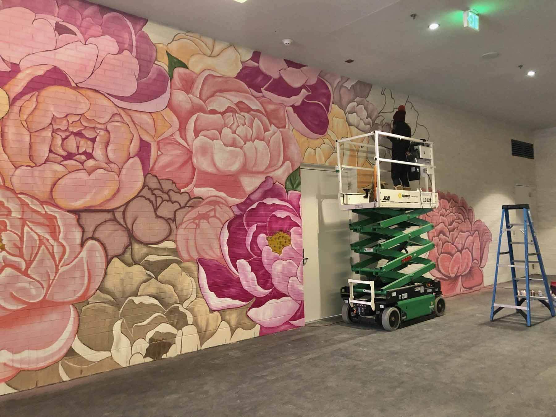 Featuring artwork by muralist Tarabella Aversa, this wall inside the Fifth + Broad development is a fun, Instagram-worthy pit stop. The artist is pictured here, putting the final touches on her masterpiece. Mural by Tarabella Aversa inside Fifth + Broad
