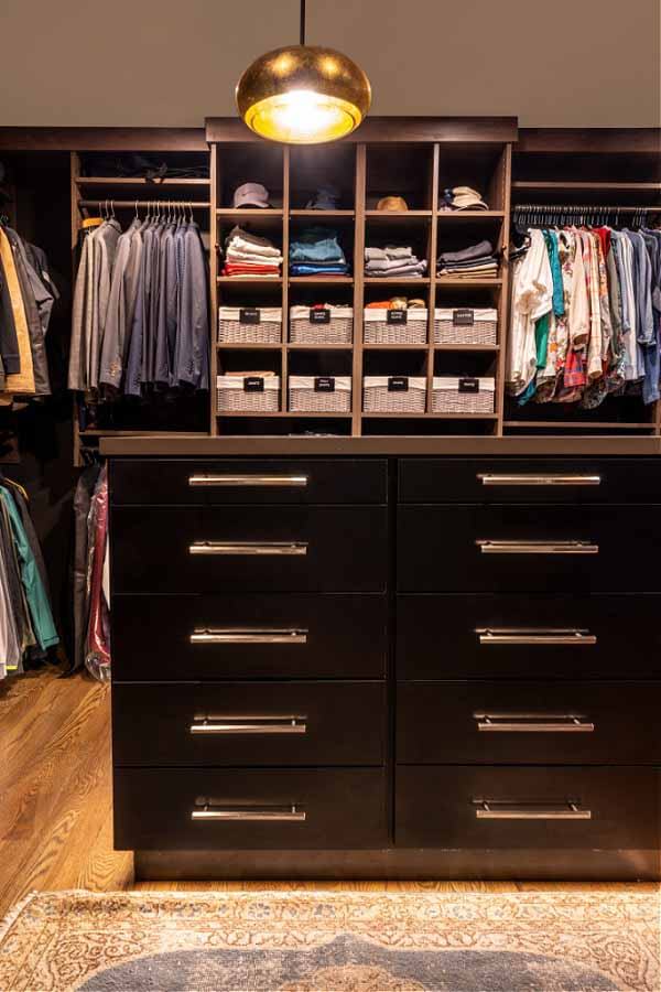 This closet layout from The Closet Company is inspiring. "This is just showing his side," says Jessica of our view. "Her side has an antique vanity." His and hers closet from the Closet Company, with a dark wood island in the center