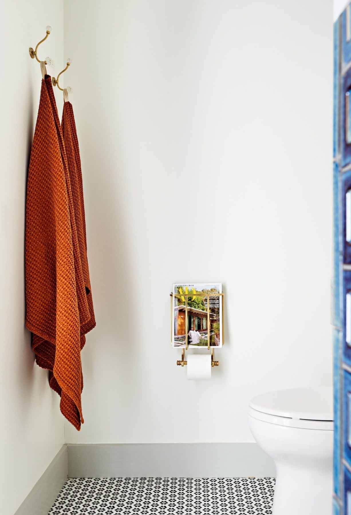 Orange towels hanging in bathroom with white walls