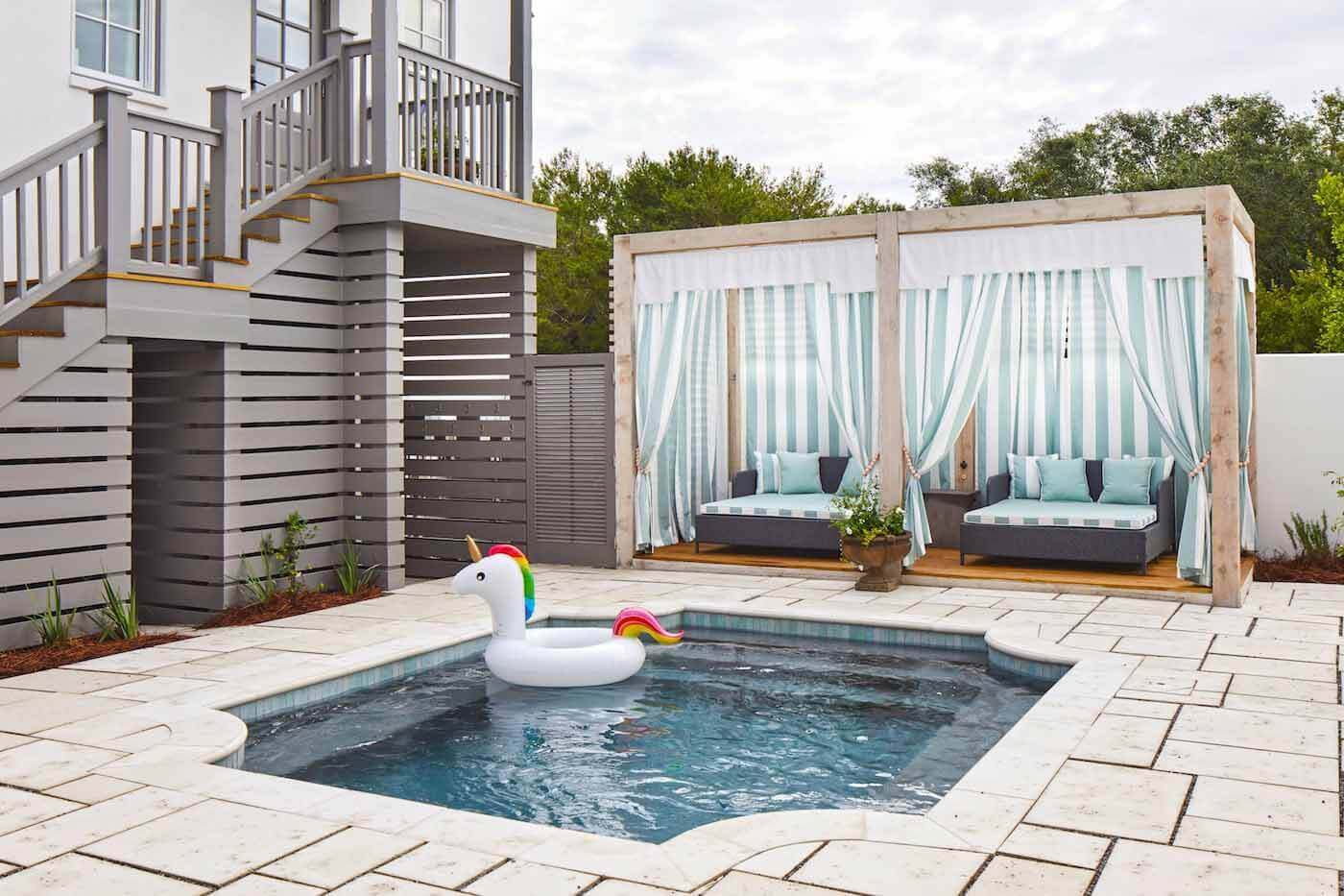 Unrecognizable to those who saw the house before the renovation, the outdoor area now features a small pool, cabanas, an outdoor shower and access to the garage, main house and carriage house. Backyard pool with unicorn floatie
