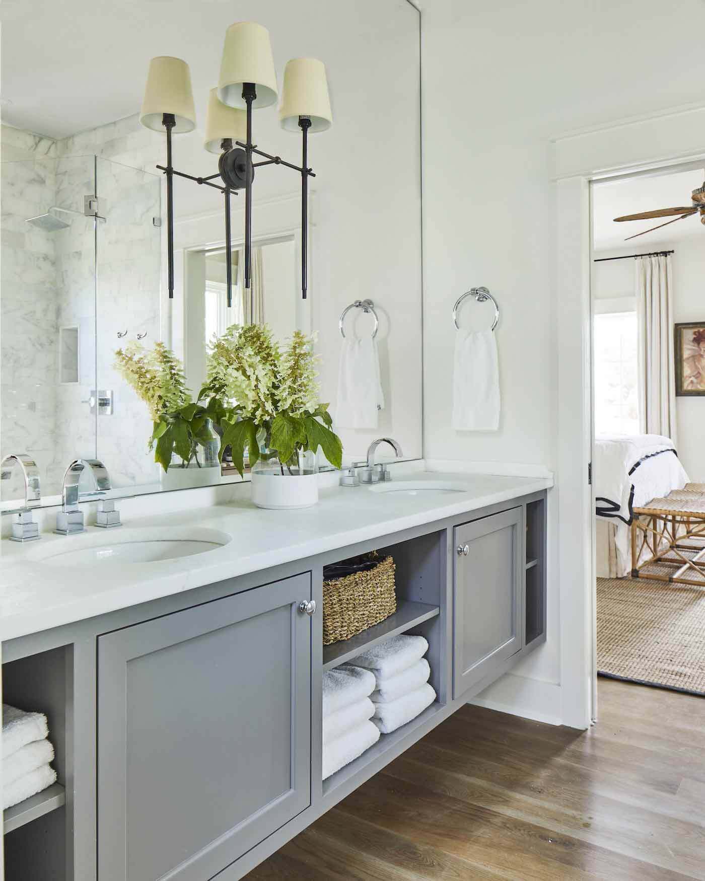 The master bathroom is also awash in natural light that streams through a window in the shower and reflects off the large mirror that stretches over the vanity. Master bathroom in Ashley Gilbreath's Rosemary beach house