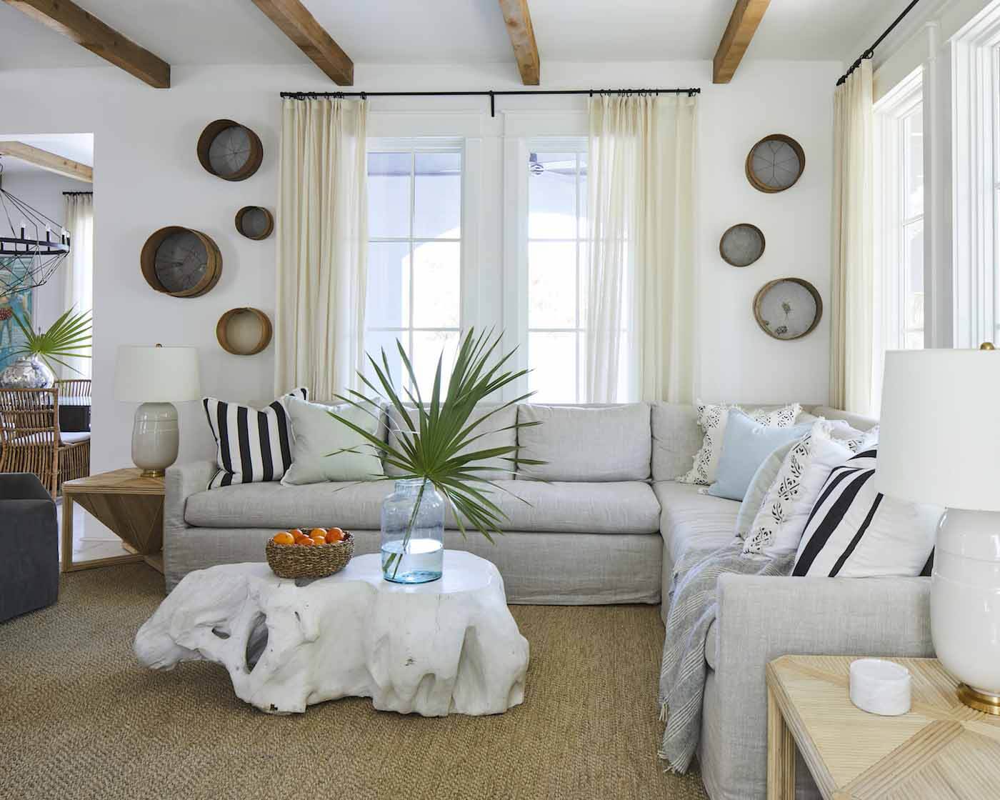 The coffee table sits at the center of the space. It has become the topic of many late-night conversations about whether it resembles a cow or an elephant or something entirely different. The slipcover sofa fits in the corner of the room, and a textured rug and sheer drapery contribute texture and visual interest. Living room with coffee table centerpiece