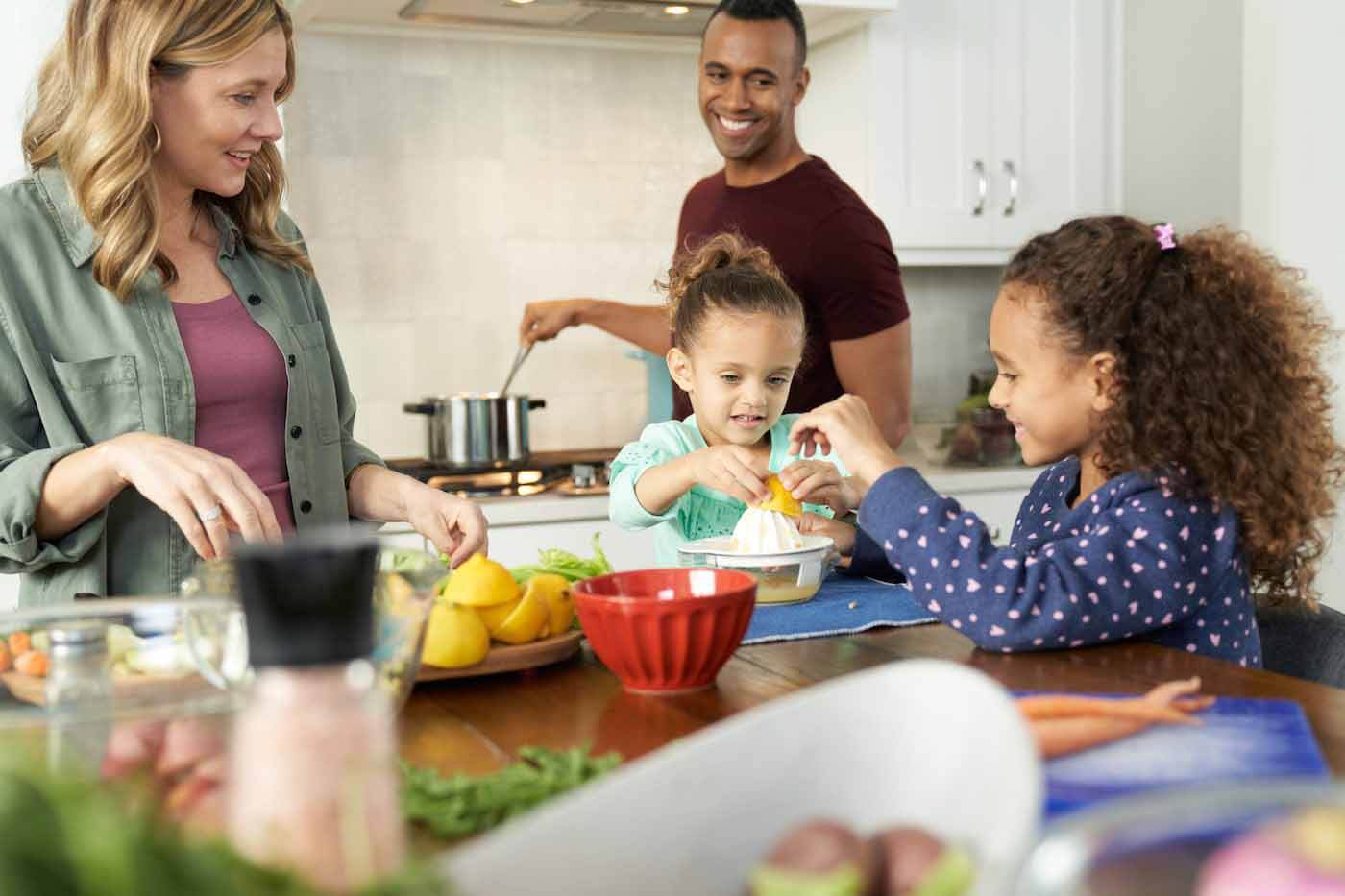 Family cooking together in kitchen protected by American Home Shield